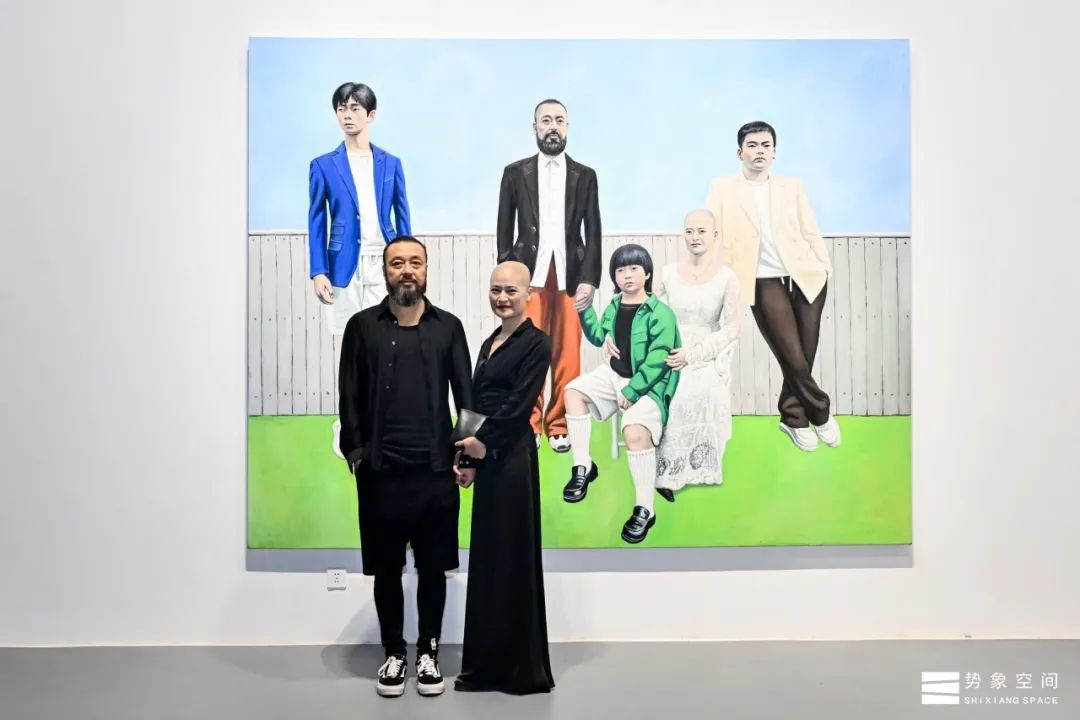 10 Artists pose in front of their works at the exhibition